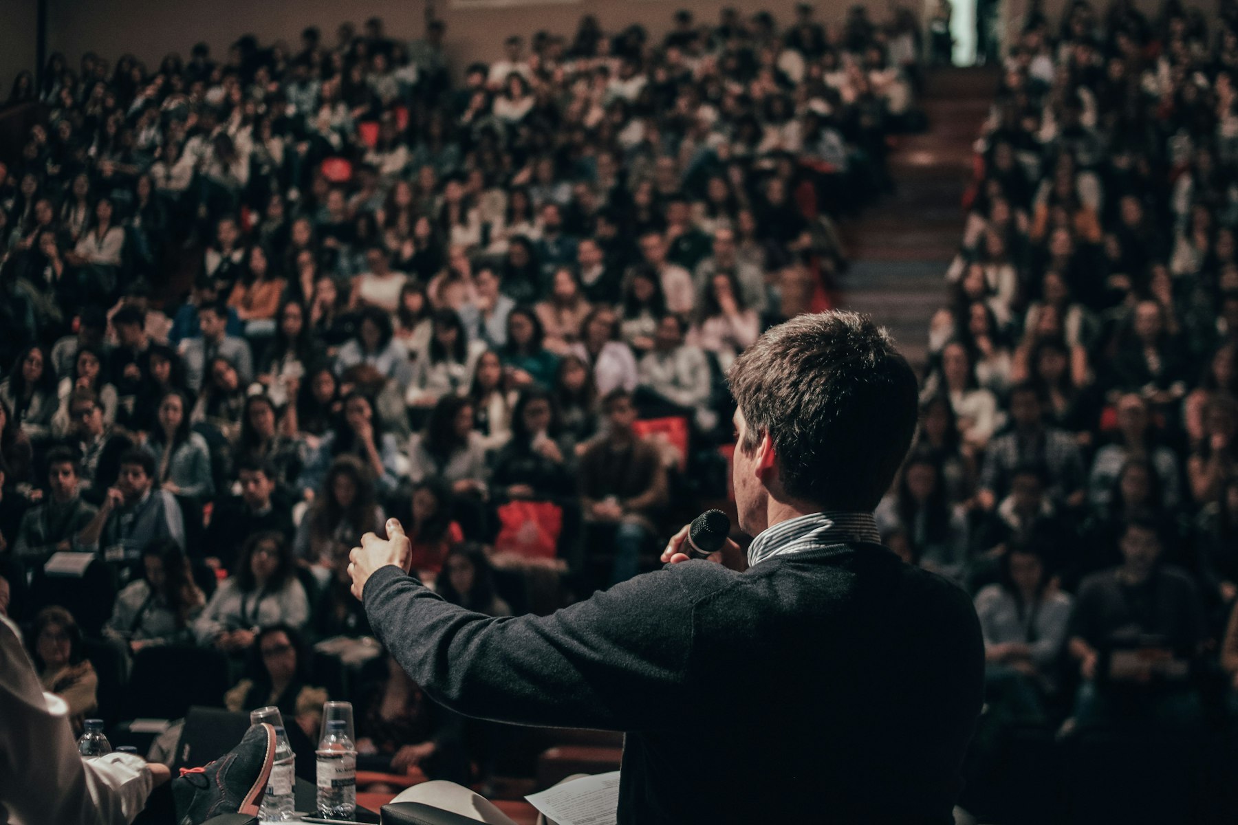 A speaker addressing a packed auditorium